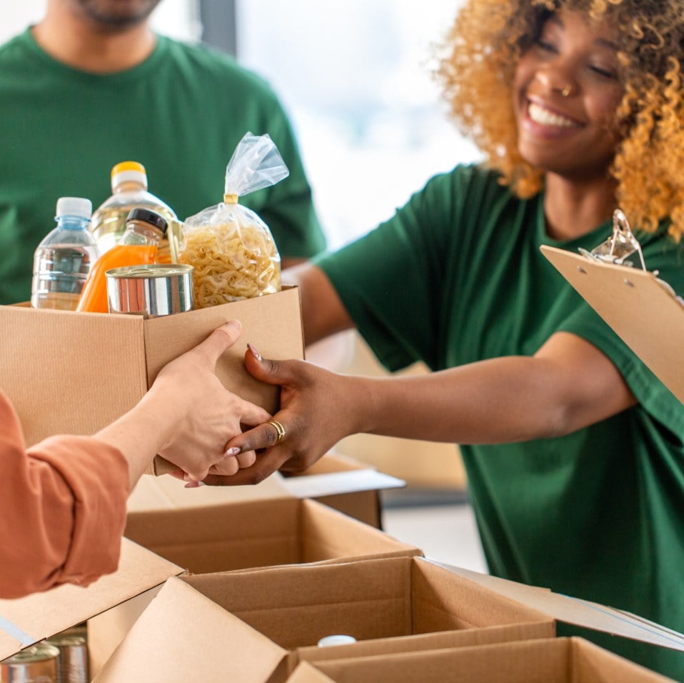 woman handing out a box of food